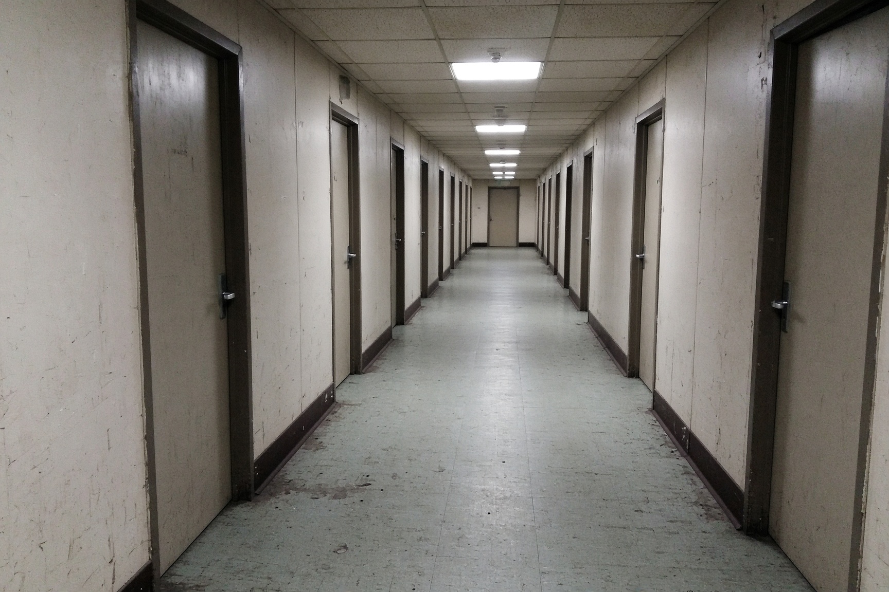 Corridor de dortoir de camp, fluos, linoléum usé